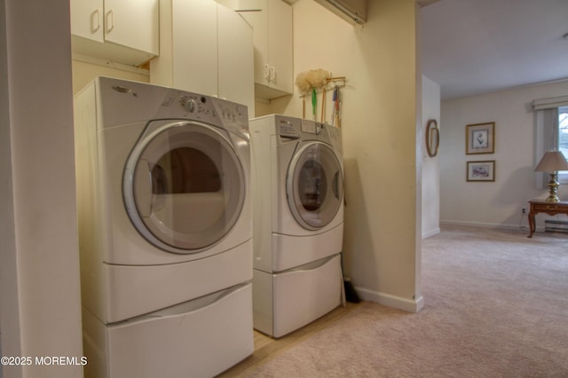 clothes washing area featuring light carpet, baseboards, and washer and dryer