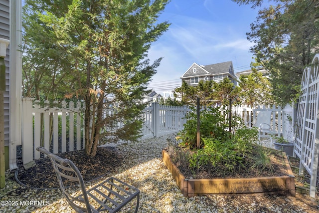 view of yard featuring fence and a garden