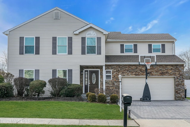 view of front of property featuring stone siding, a front lawn, decorative driveway, and an attached garage