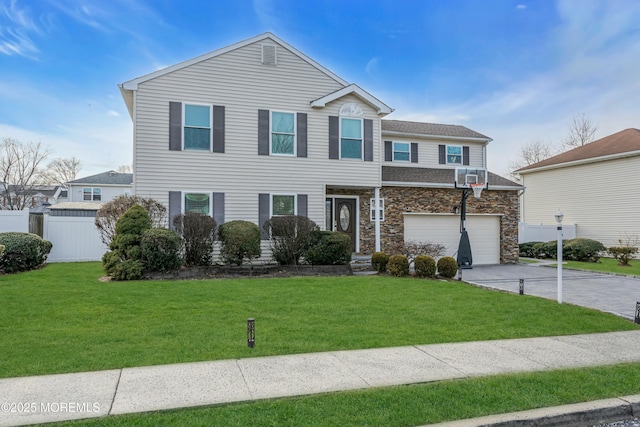 view of front of property featuring driveway, stone siding, fence, and a front yard