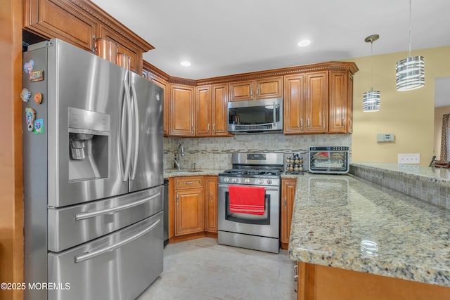 kitchen with appliances with stainless steel finishes, brown cabinets, light stone counters, and decorative backsplash