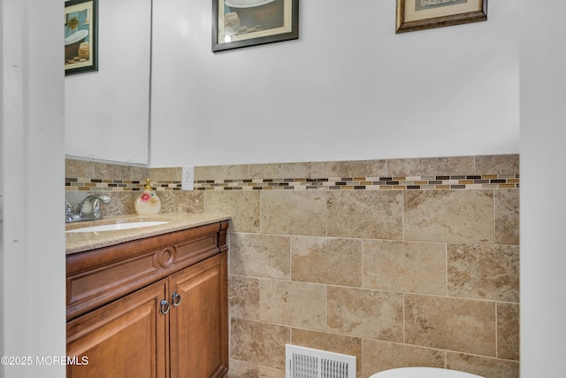 bathroom featuring tile walls, visible vents, vanity, and toilet