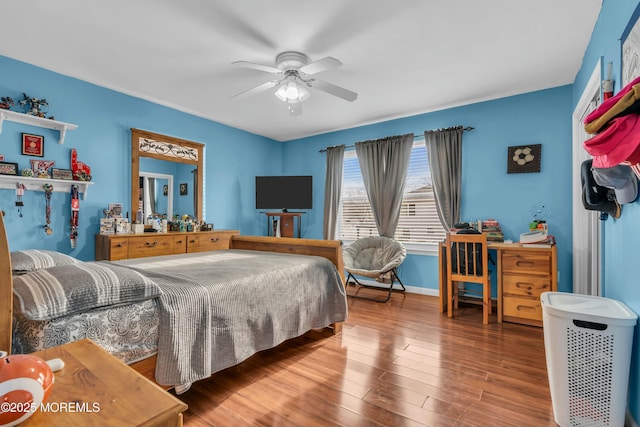 bedroom featuring a ceiling fan, baseboards, and wood finished floors