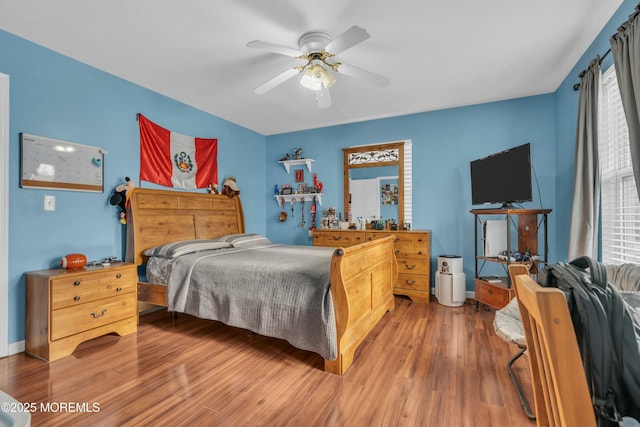 bedroom featuring ceiling fan, baseboards, and wood finished floors