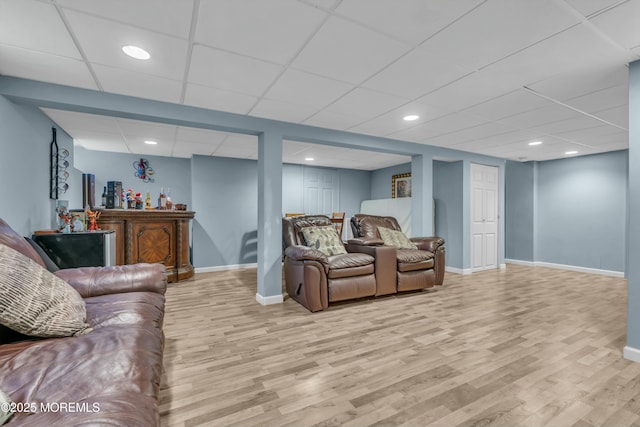 living area featuring recessed lighting, a drop ceiling, baseboards, and wood finished floors