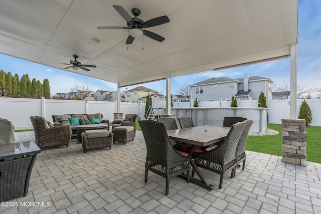 view of patio / terrace featuring ceiling fan, a fenced backyard, an outdoor hangout area, and outdoor dining space