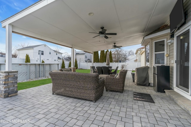 view of patio with outdoor dining space, a fenced backyard, an outdoor living space, and a ceiling fan