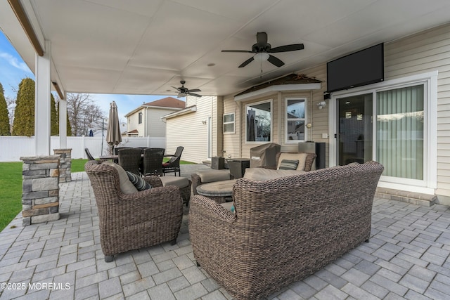 view of patio / terrace with ceiling fan, fence, an outdoor hangout area, and outdoor dining space