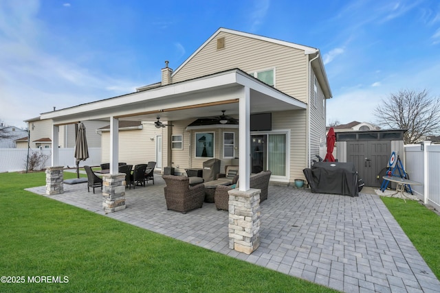 rear view of property featuring a yard, a patio, a storage unit, a fenced backyard, and an outdoor structure