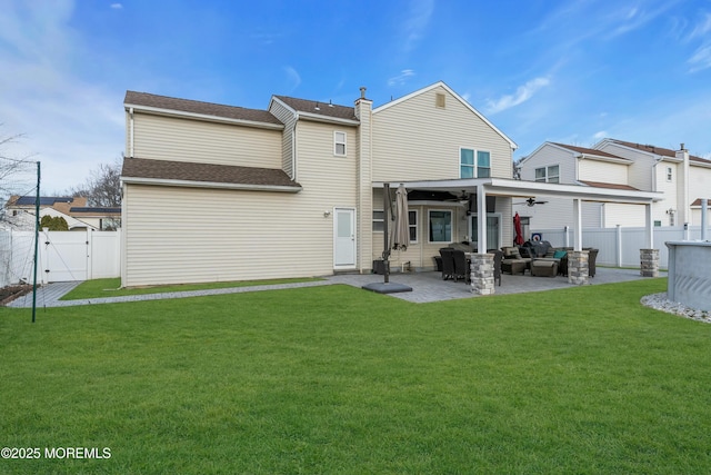 back of house with ceiling fan, a fenced backyard, a lawn, a gate, and a patio area