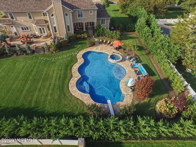 view of pool featuring a lawn, a pool with connected hot tub, and a patio