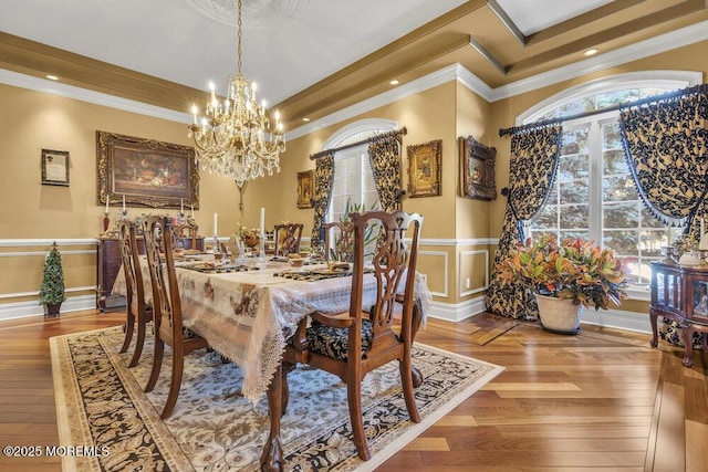 dining area featuring a wealth of natural light, wainscoting, crown molding, and a decorative wall