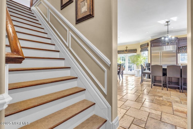 stairway with stone tile flooring, a notable chandelier, recessed lighting, and ornamental molding