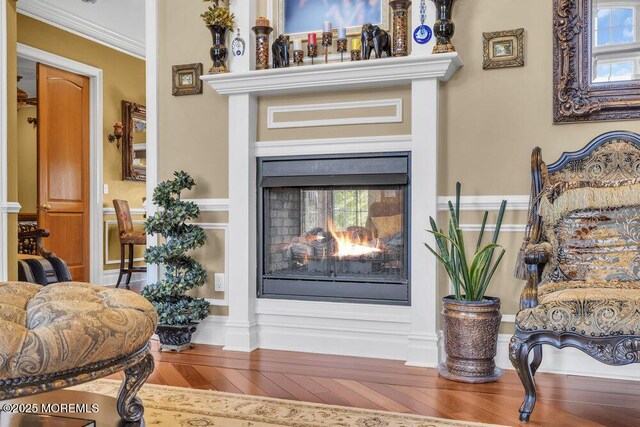 details with a multi sided fireplace, wood finished floors, and crown molding