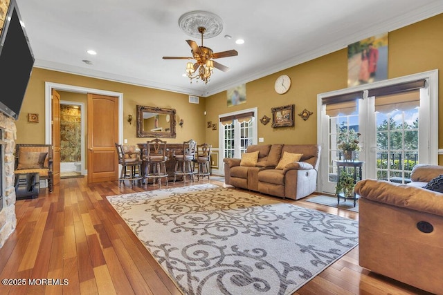 living room with a wealth of natural light, french doors, hardwood / wood-style flooring, and ornamental molding