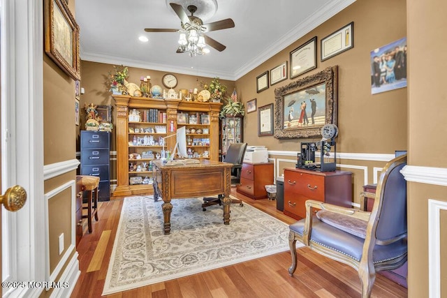 office area featuring wainscoting, crown molding, a ceiling fan, and wood finished floors