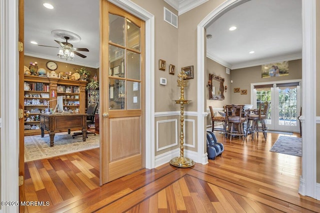 interior space with hardwood / wood-style floors, crown molding, and visible vents