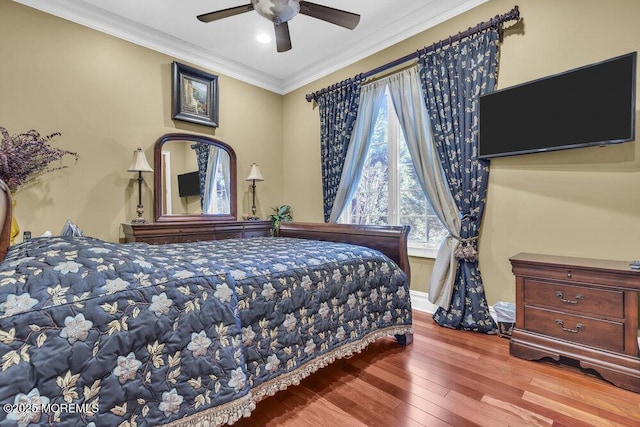 bedroom featuring baseboards, a ceiling fan, wood finished floors, and crown molding