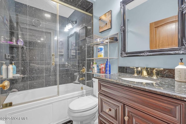 bathroom with vanity, toilet, and combined bath / shower with glass door