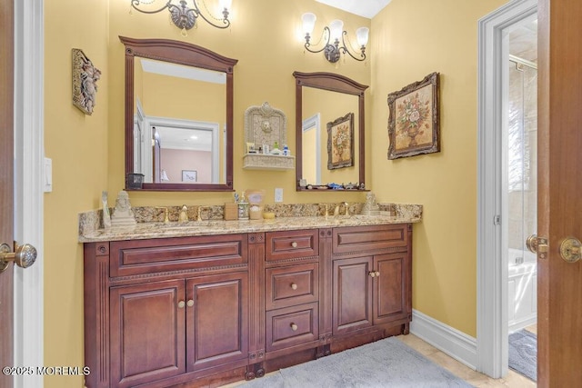 bathroom featuring a sink, a tub, baseboards, and double vanity