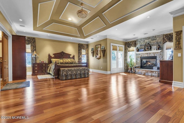 bedroom with a fireplace, baseboards, wood-type flooring, and ornamental molding