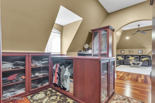 interior space featuring hardwood / wood-style floors, a ceiling fan, lofted ceiling, arched walkways, and wine cooler