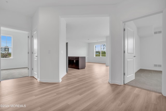 spare room with light wood-style floors, baseboards, and visible vents