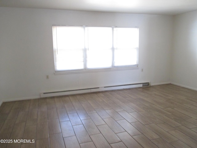 empty room with a baseboard radiator and wood finished floors