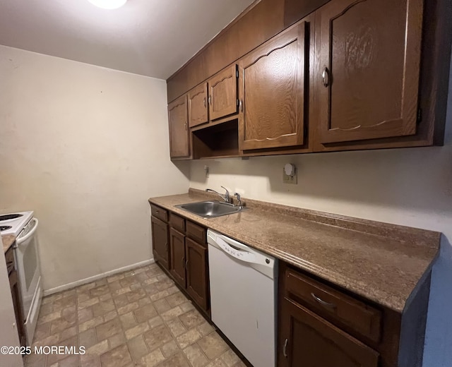 kitchen with dark brown cabinets, white appliances, a sink, and baseboards