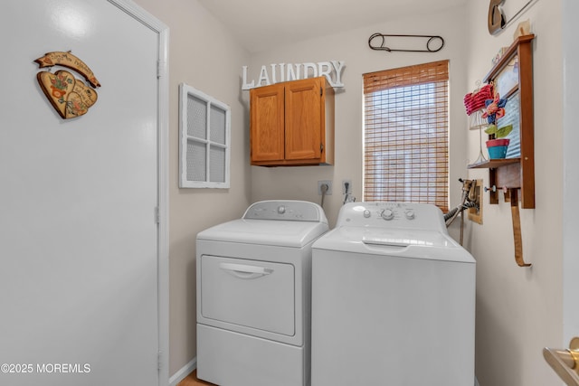 clothes washing area featuring washer and dryer and cabinet space