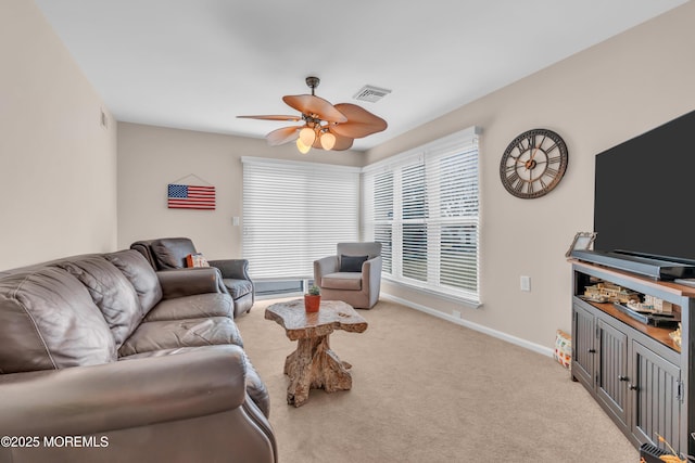 carpeted living area with baseboards, visible vents, and a ceiling fan