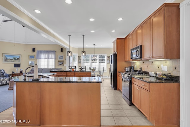 kitchen with recessed lighting, a sink, a large island, decorative backsplash, and black appliances