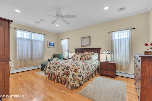 bedroom with light wood-style flooring, a baseboard radiator, and visible vents