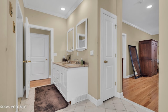 hallway with light tile patterned floors, baseboards, crown molding, and recessed lighting