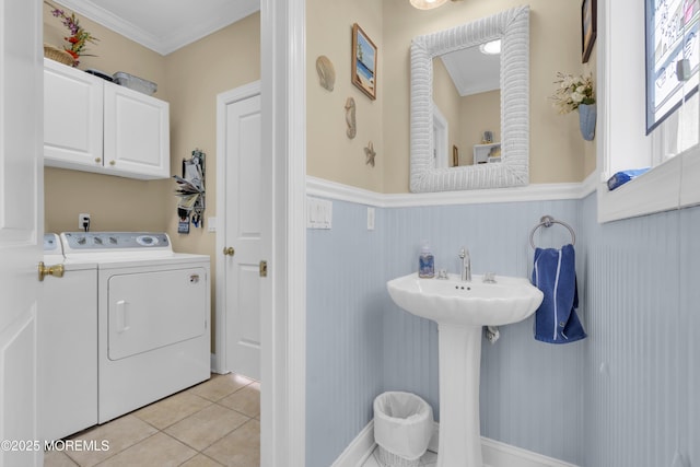 bathroom featuring wainscoting, ornamental molding, tile patterned flooring, washer and dryer, and a sink