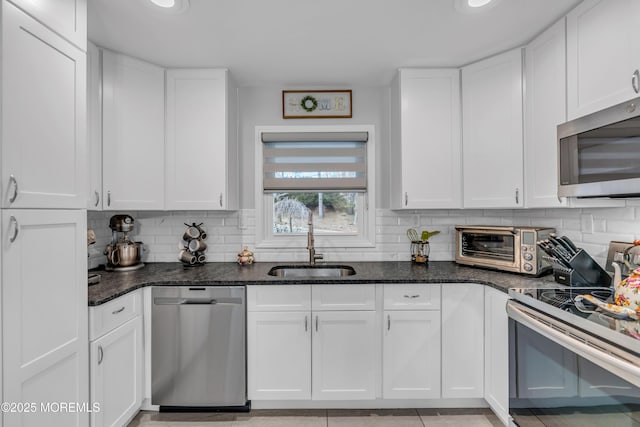 kitchen featuring white cabinetry, appliances with stainless steel finishes, tasteful backsplash, and a sink