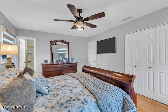 bedroom with ceiling fan, connected bathroom, visible vents, a closet, and light wood-type flooring