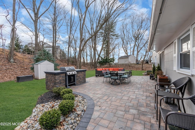 view of patio featuring outdoor dining space, a storage unit, grilling area, and an outbuilding