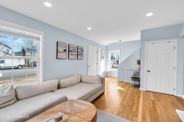 living area with a wealth of natural light, light wood-style flooring, baseboards, and recessed lighting