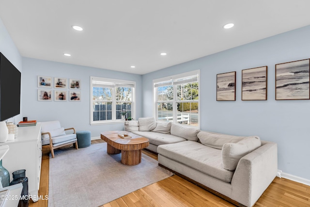 living area featuring recessed lighting, baseboards, and light wood finished floors