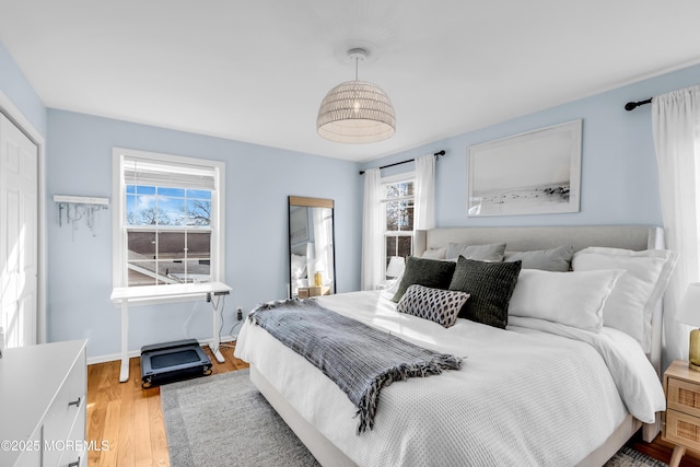 bedroom featuring light wood-style flooring and baseboards