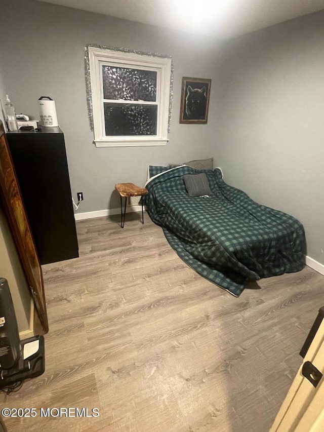 bedroom with wood finished floors and baseboards