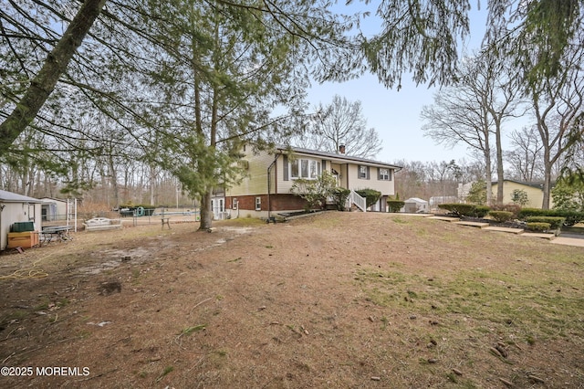 view of front of property featuring a chimney and brick siding