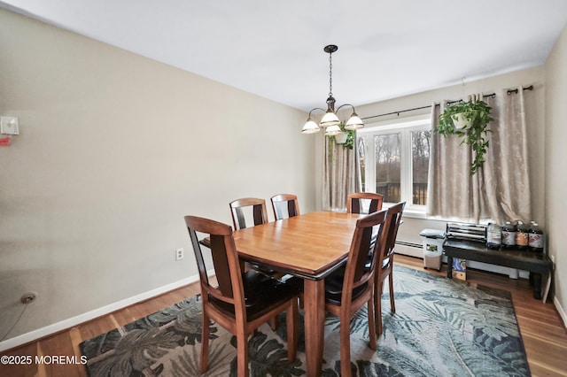 dining space featuring a chandelier, baseboards, and wood finished floors