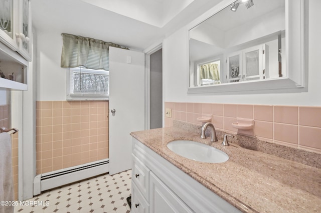 bathroom featuring a baseboard heating unit, a wainscoted wall, vanity, and tile walls