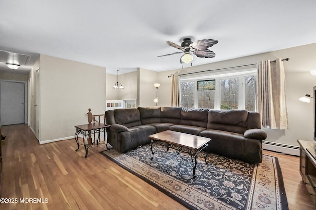 living room with attic access, baseboards, a ceiling fan, a baseboard radiator, and wood finished floors