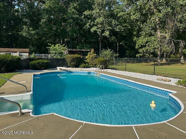 view of pool featuring fence, a diving board, and a fenced in pool