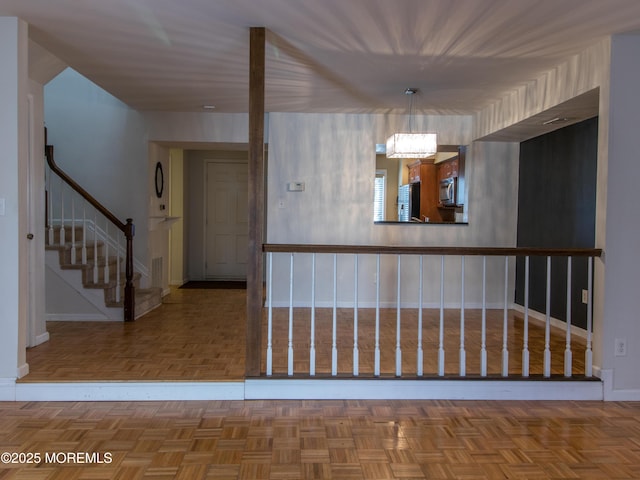 hall featuring stairway and baseboards