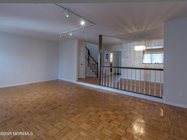 unfurnished room featuring baseboards and stairs