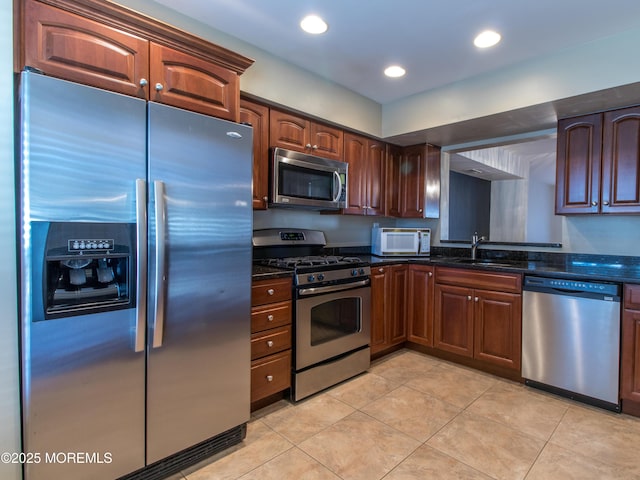 kitchen with light tile patterned floors, stainless steel appliances, recessed lighting, a sink, and dark stone countertops